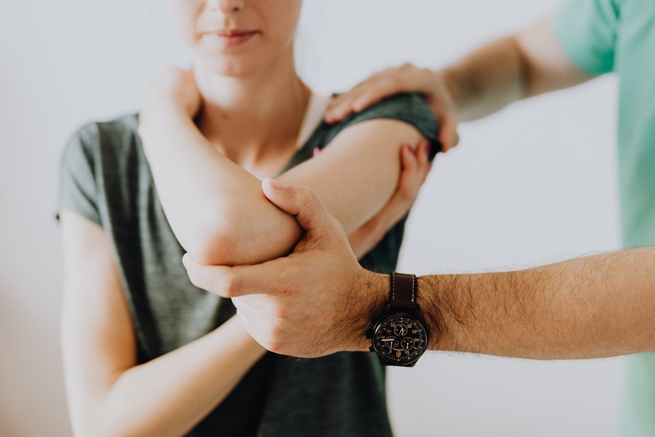 A chiropractor adjusting a patients arm in a clinic setting, focusing on health and care.